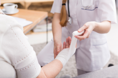 nurse changing bandage on hand